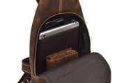 Zaino in pelle marrone con tasca aperta, contenente tablet, smartphone e portafoglio. Design elegante e funzionale, ideale per viaggi e lavoro.