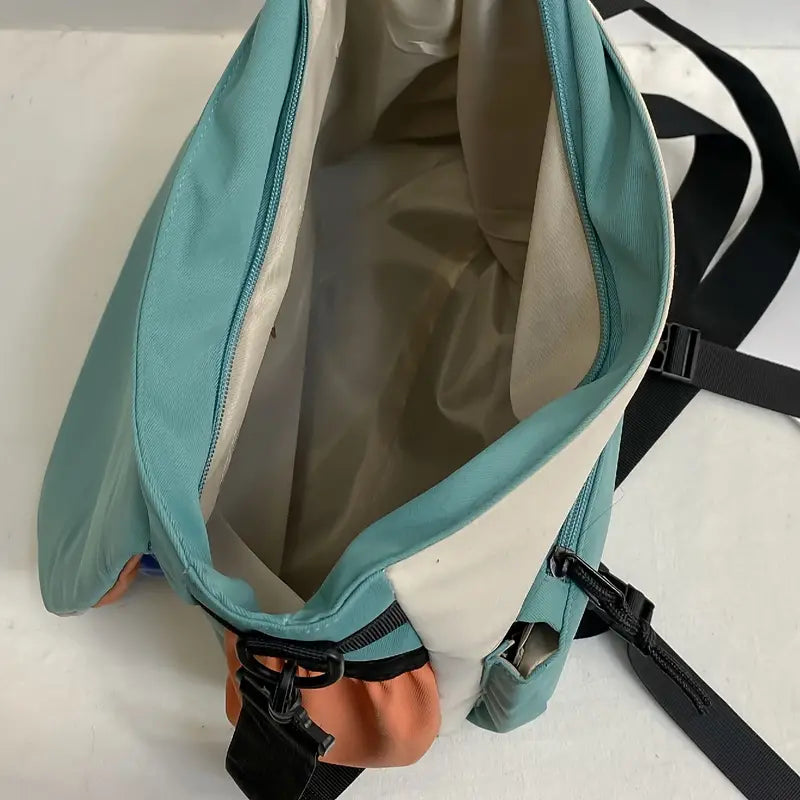 Zaino aperto verde acqua e beige, design moderno, tasche multiple, cerniere nere, ideale per viaggi e uso quotidiano.