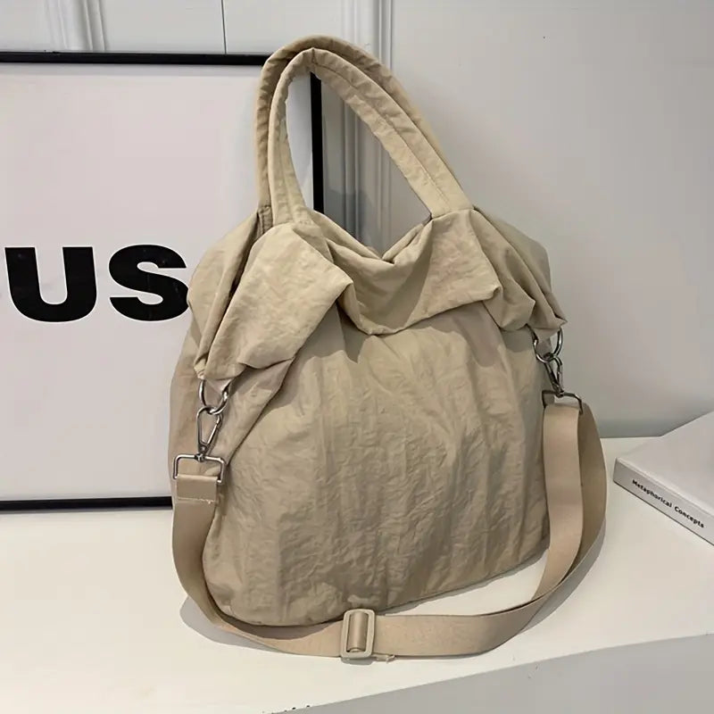 Borsa a tracolla beige in tessuto morbido, design casual con manici e tracolla regolabile. Perfetta per uso quotidiano e shopping.