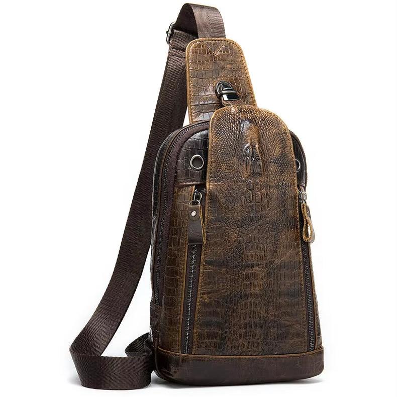 Zaino monospalla in pelle marrone con texture coccodrillo, cerniere multiple e tracolla regolabile. Elegante e pratico per uso quotidiano.