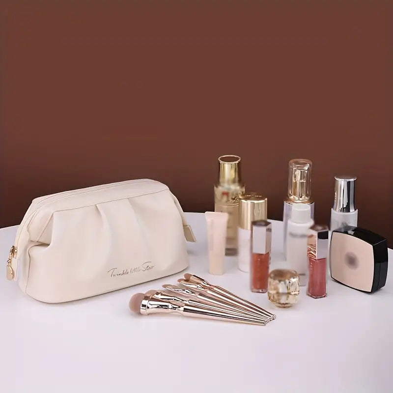 Set di cosmetici su tavolo bianco: borsa trucco beige, pennelli, flaconi di profumo e creme. Elegante e organizzato, ideale per beauty routine.