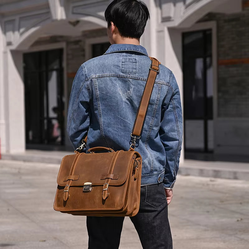 Uomo con giacca di jeans e borsa a tracolla in pelle marrone, stile casual urbano, moda maschile, accessori eleganti, strada cittadina.