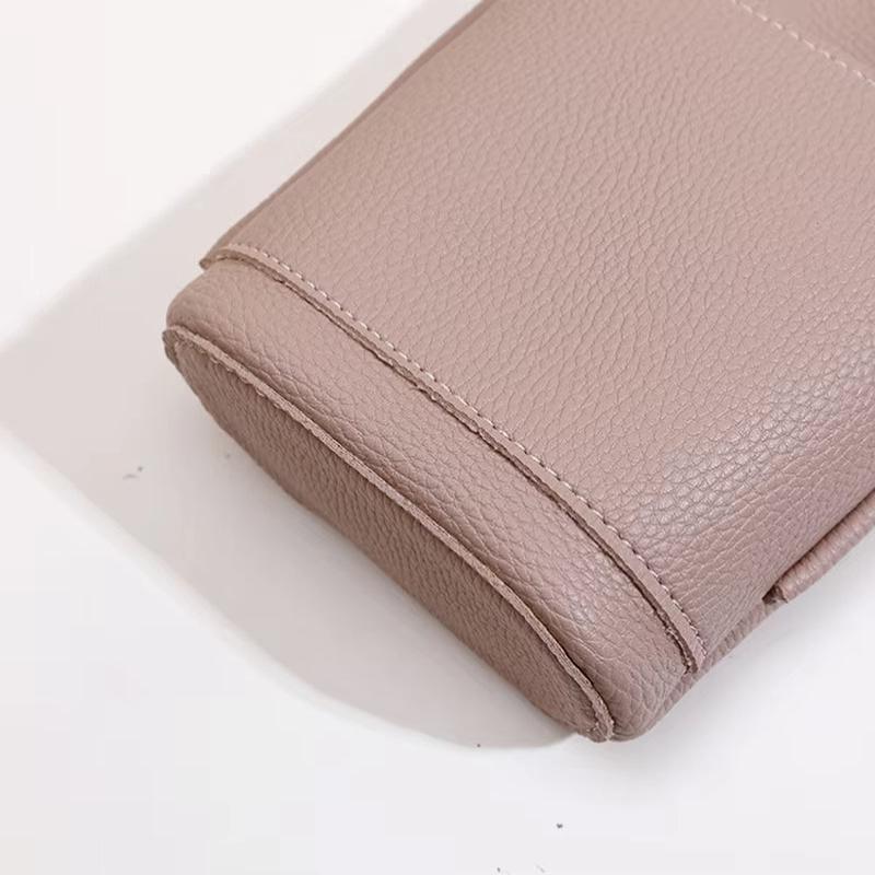 Borsa in pelle beige chiaro, texture granulosa, cuciture a vista, design elegante e moderno, accessorio moda donna, alta qualità.