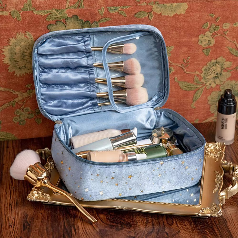 Astuccio trucco blu con stelle, pennelli cosmetici e flaconi su vassoio dorato. Set make-up elegante, accessori bellezza, organizzazione trucco.