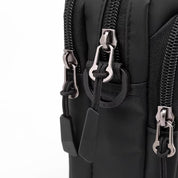 Zaino nero con cerniere multiple in metallo, design moderno e resistente, ideale per viaggi e uso quotidiano. Tasche capienti e pratiche.