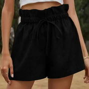 Shorts neri a vita alta con cintura arricciata e laccio, indossati da una donna. Moda estiva, abbigliamento casual femminile.