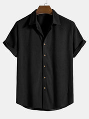 Camicia nera a maniche corte in cotone, design casual con colletto classico e bottoni marroni. Ideale per moda estiva uomo.
