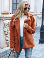 Donna con cappotto teddy arancione, jeans strappati e occhiali da sole. Moda autunnale, abbigliamento casual chic, look urbano elegante.