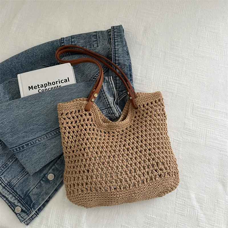 Borsa a rete in paglia con manici in pelle su jeans e libro, moda estiva, accessori donna, stile casual chic, tendenze 2023.