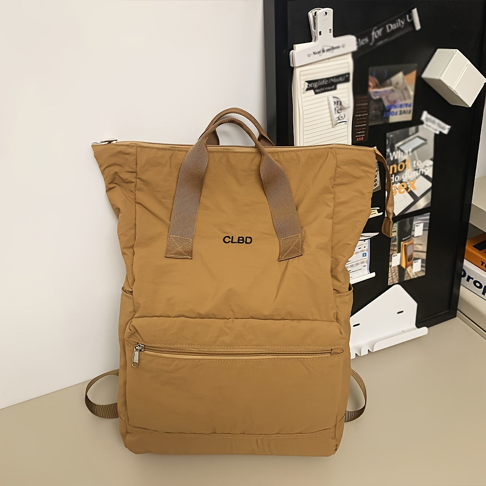 Zaino beige CLBD in tessuto resistente, con manici in pelle e tasca frontale con zip, posizionato su scrivania moderna.