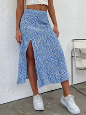 Gonna lunga blu a fiori con spacco laterale, indossata con top bianco e sneakers bianche. Moda estiva casual donna, abbigliamento trendy.