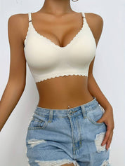 Reggiseno bianco senza cuciture, design a balconcino, indossato con shorts di jeans strappati. Intimo donna comodo e alla moda.
