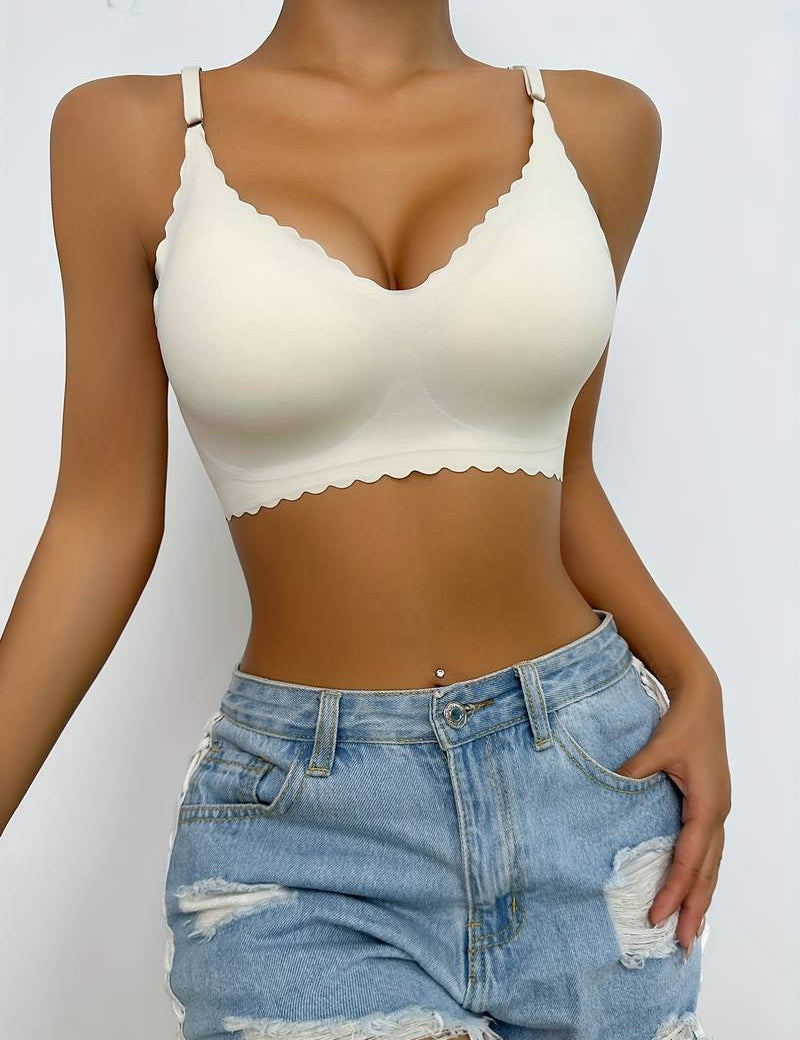 Modella indossa reggiseno bianco senza cuciture con bordo ondulato e shorts di jeans strappati. Intimo comodo, moda estiva, abbigliamento casual.