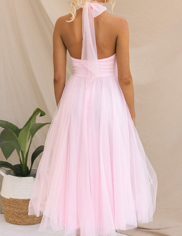 Abito da sera rosa chiaro in tulle, senza spalline, con fiocco al collo. Design elegante e femminile, perfetto per eventi formali e cerimonie.