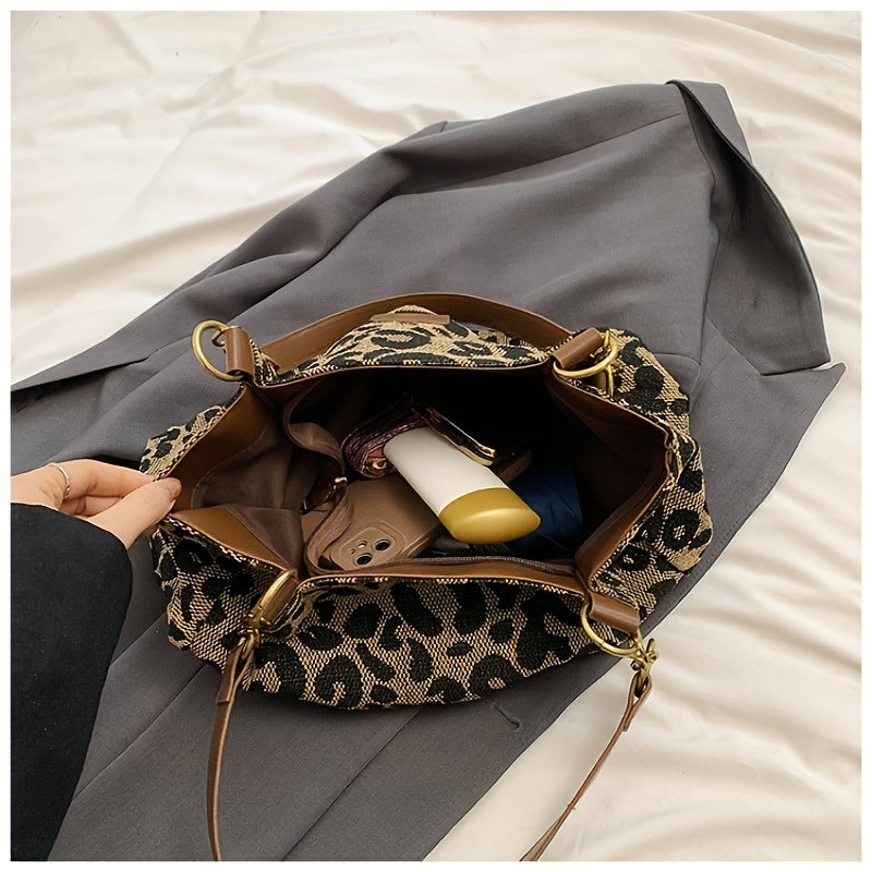 Borsa a tracolla leopardata aperta su cappotto grigio, contenente portafoglio, rossetto e altri oggetti. Accessorio moda donna elegante e pratico.
