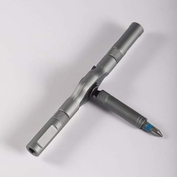 Cacciavite multifunzione in metallo grigio, design ergonomico, con punte intercambiabili. Strumento versatile per fai da te e riparazioni.