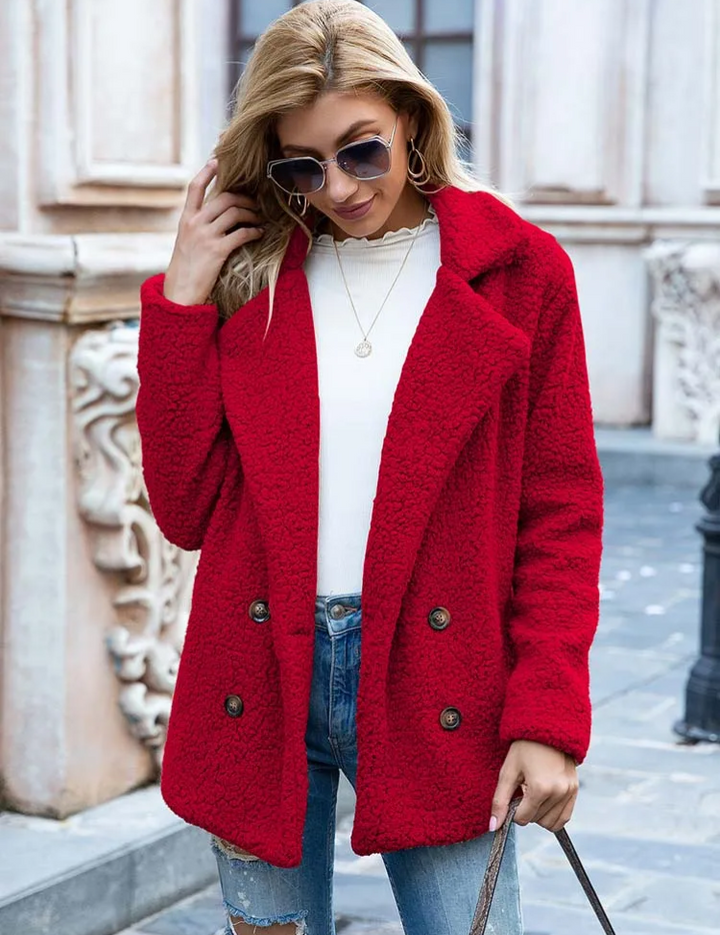 Donna con cappotto rosso in lana, occhiali da sole, jeans strappati e maglia bianca. Moda autunnale, abbigliamento casual elegante.