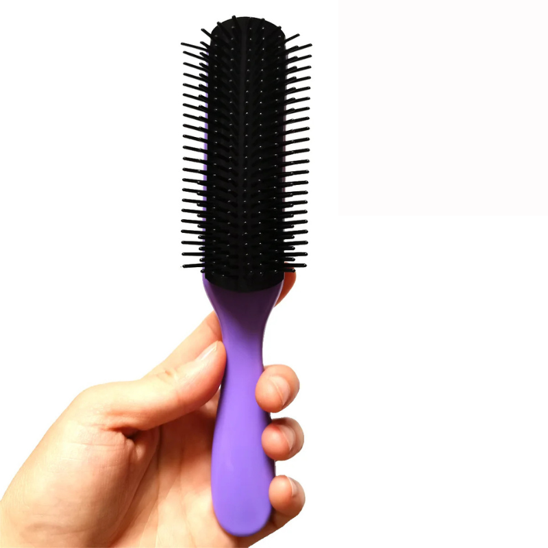 Spazzola per capelli viola con setole nere, impugnatura ergonomica, ideale per districare e lisciare, tenuta in mano. Accessorio styling capelli.