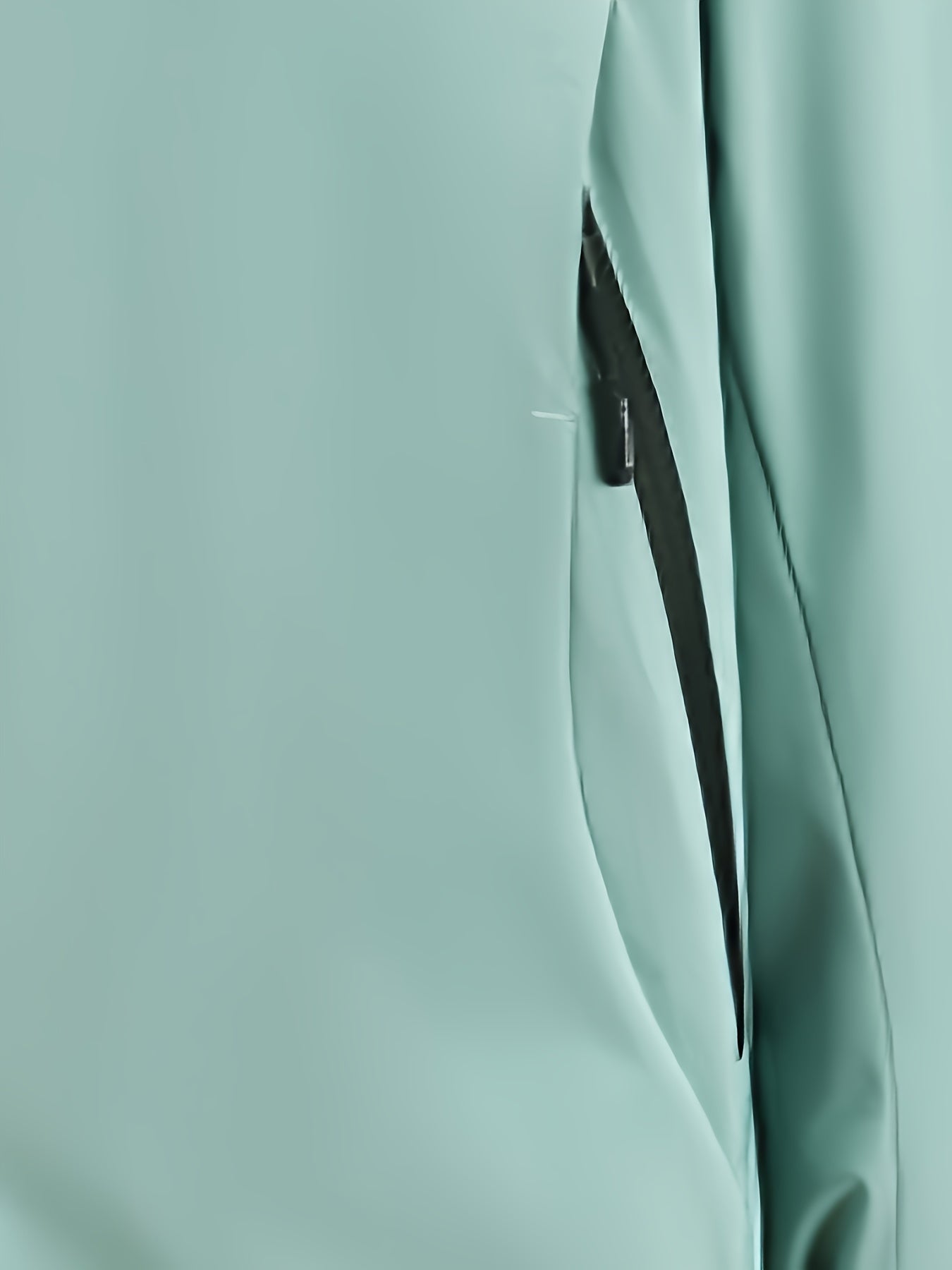 Giacca impermeabile verde menta con cerniera nera, tessuto resistente all'acqua, ideale per attività outdoor e sport all'aperto.