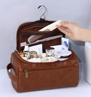 Beauty case in pelle marrone aperto con prodotti cosmetici e accessori per la cura personale. Design elegante, ideale per viaggi e organizzazione.