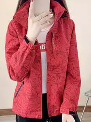 Giacca rossa donna con motivo floreale, zip frontale, indossata sopra maglietta bianca. Moda autunnale, abbigliamento casual elegante.