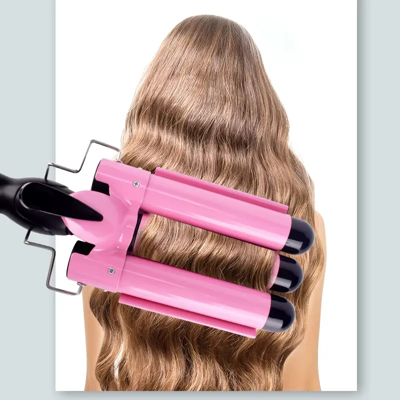 Ferro arricciacapelli triplo rosa su capelli ondulati biondi, styling professionale, acconciatura volumizzante, strumento per onde morbide.