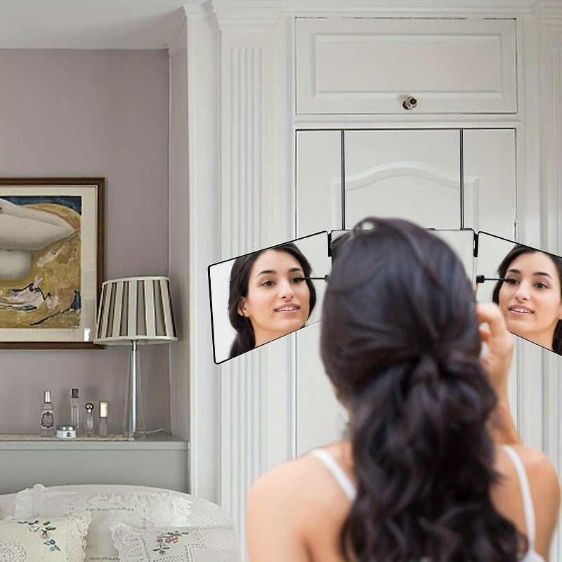 Donna che si guarda in uno specchio triplo pieghevole in camera da letto elegante, con lampada e quadro. Specchio trucco, arredamento moderno.