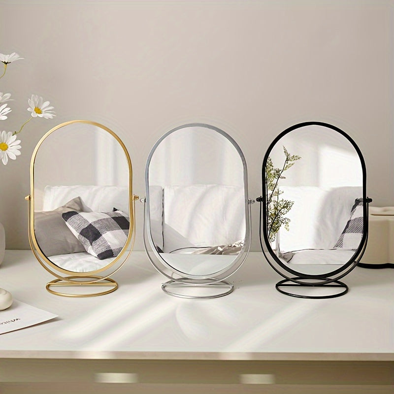 Specchio da tavolo ovale con cornice in metallo, disponibile in oro, argento e nero. Design moderno, ideale per arredamento camera da letto o bagno.