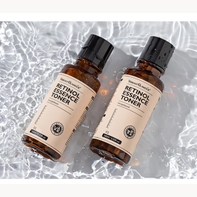 Due bottiglie di tonico al retinolo su sfondo d'acqua, etichetta "Retinol Essence Toner", design elegante, skincare, bellezza, cura della pelle.