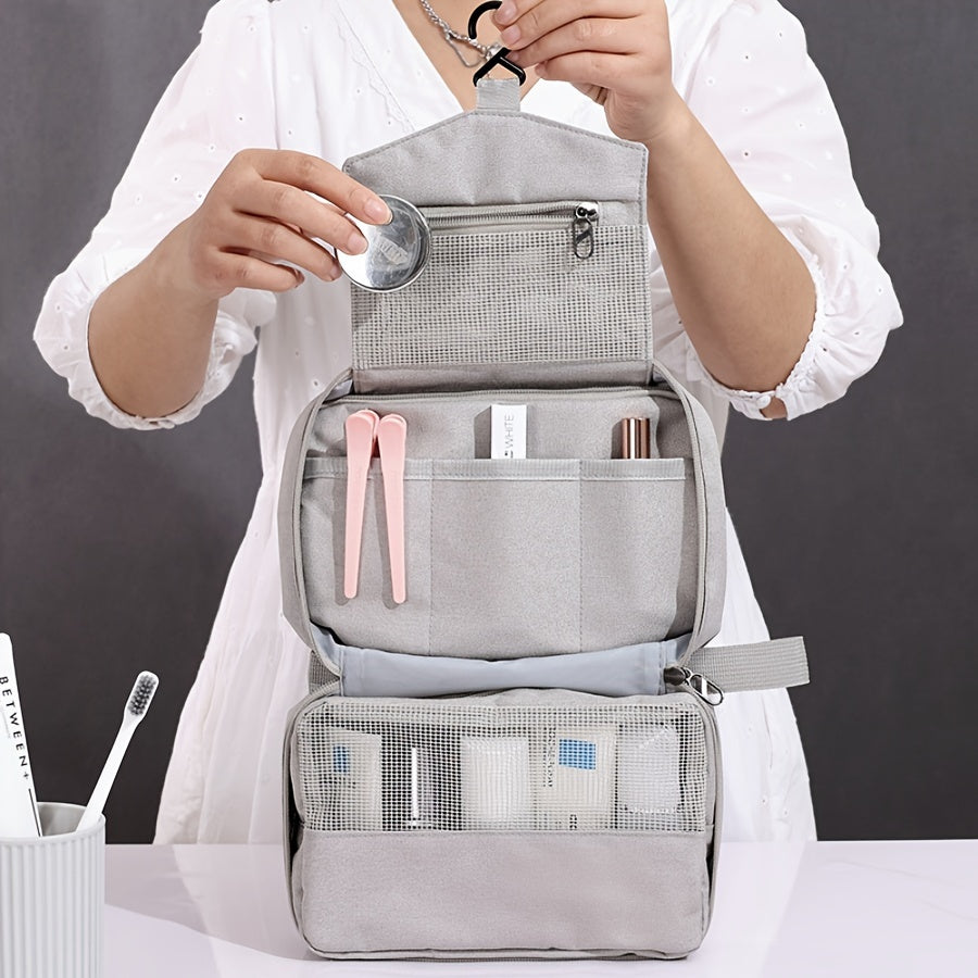 Borsa da toilette grigia appesa, con scomparti multipli, contenente articoli da bagno e accessori. Ideale per viaggi e organizzazione bagno.