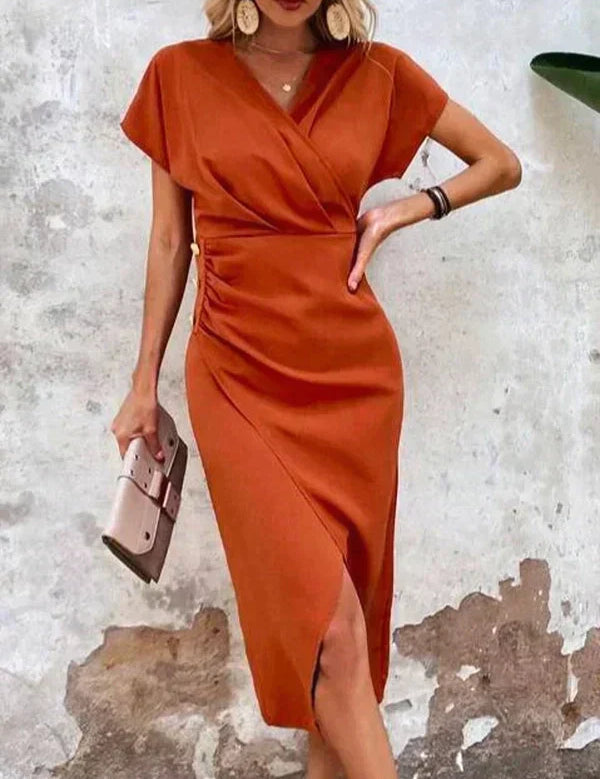 Abito arancione elegante con scollo a V e spacco laterale, indossato da donna con accessori moda. Perfetto per eventi formali e serate estive.