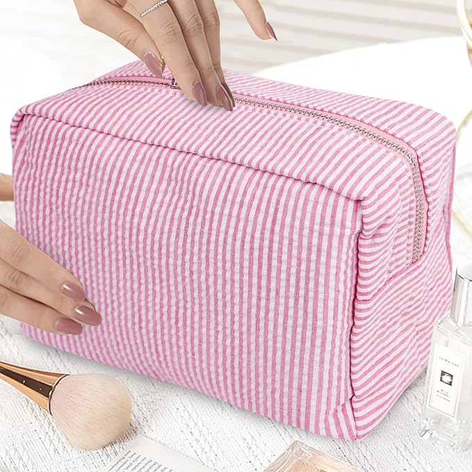 Astuccio cosmetico a righe rosa e bianche, spazioso e con cerniera, ideale per organizzare trucchi e accessori da viaggio.