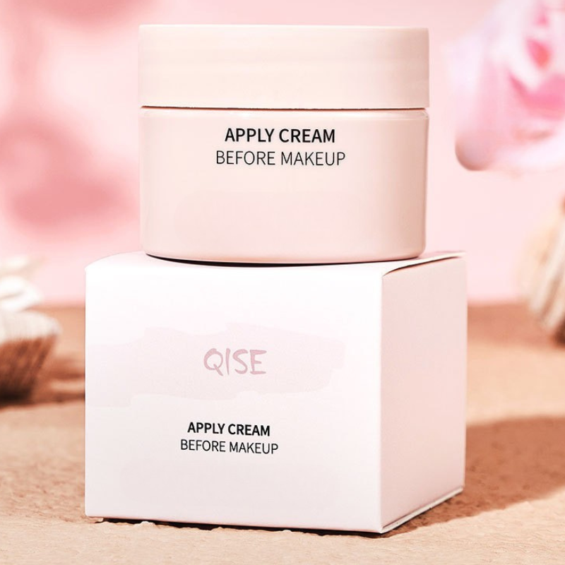 Crema viso Qise su scatola, design elegante, ideale come base trucco. Idratante, skincare, bellezza quotidiana, confezione rosa minimalista.