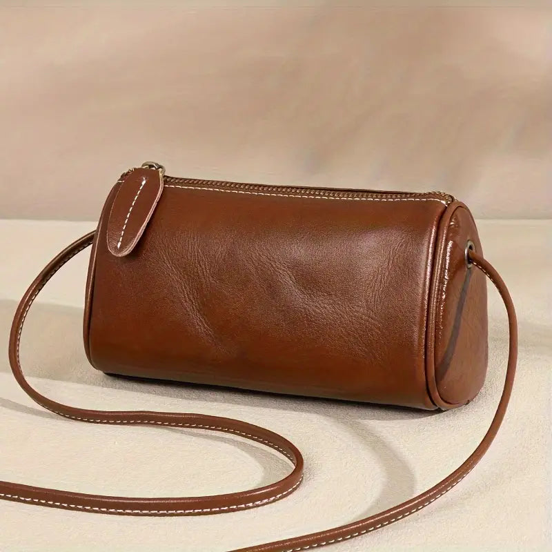 Borsa a tracolla cilindrica in pelle marrone, design elegante e minimalista, perfetta per moda donna, accessori di lusso, stile casual chic.