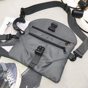 Marsupio grigio unisex in nylon con cerniere multiple e fibbie regolabili, ideale per viaggi e attività all'aperto. Design moderno e funzionale.