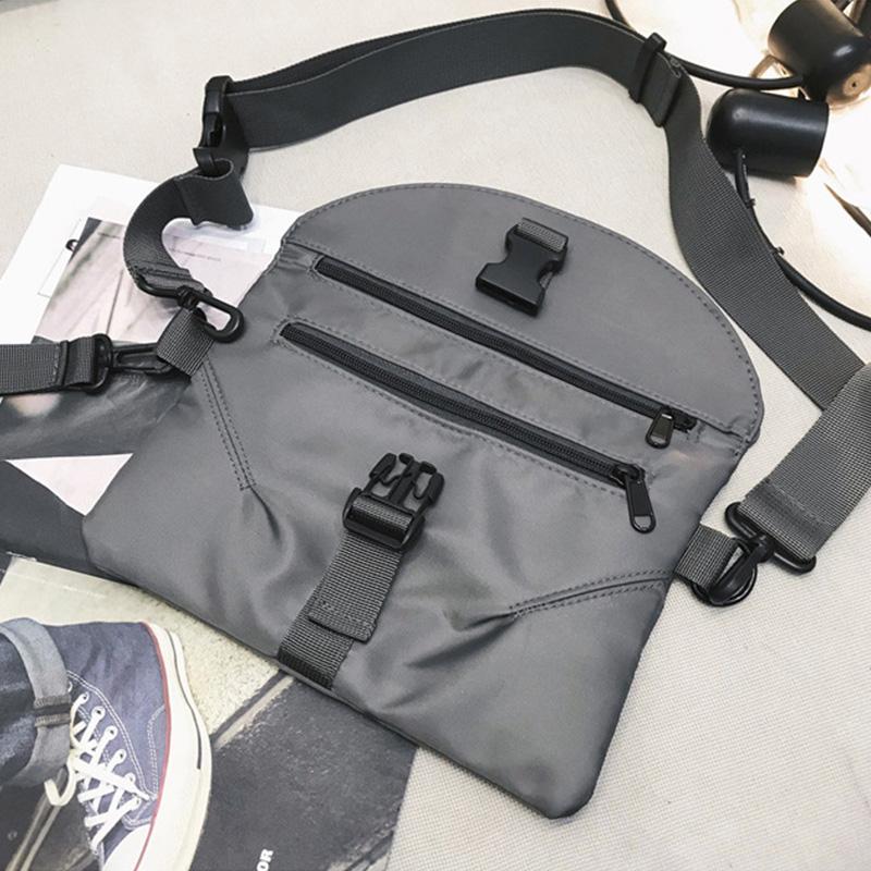 Marsupio grigio unisex in nylon con cerniere multiple e fibbie regolabili, ideale per viaggi e attività all'aperto. Design moderno e funzionale.