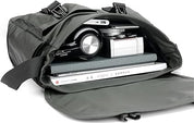 Borsa a tracolla nera aperta con fotocamera, laptop e quaderno all'interno. Ideale per viaggi, lavoro e fotografia. Accessori tecnologici organizzati.