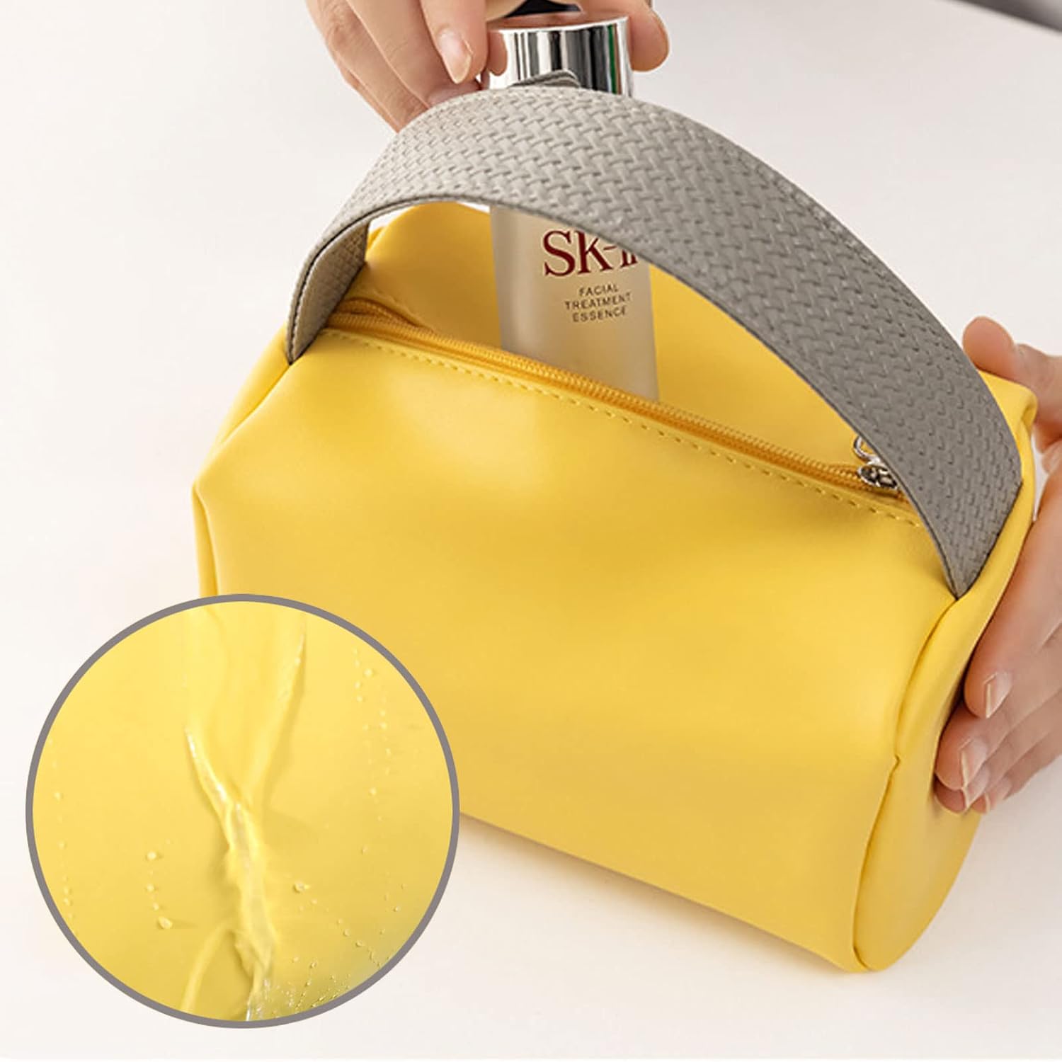 Borsa cosmetica gialla impermeabile con cerniera, manico grigio intrecciato, ideale per viaggio. Include flacone SK-II. Design elegante e pratico.