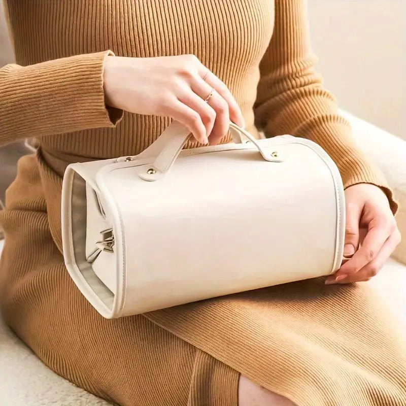 Donna con abito beige tiene borsa a mano cilindrica bianca in pelle, elegante e moderna. Accessorio moda femminile, stile minimalista.