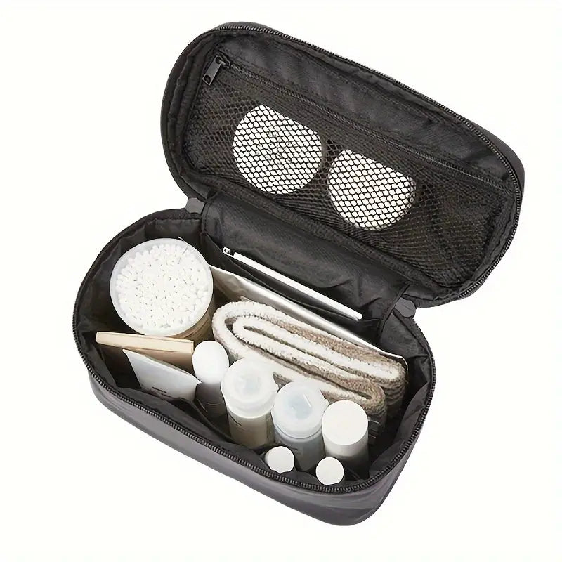 Borsa da toilette nera aperta con scomparti, contenente flaconi da viaggio, dischetti di cotone, asciugamano e accessori per la cura personale.