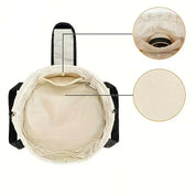 Borsa a tracolla beige con tasche interne, design rotondo, chiusura con cerniera, ideale per viaggi e uso quotidiano. Materiale resistente e spazioso.
