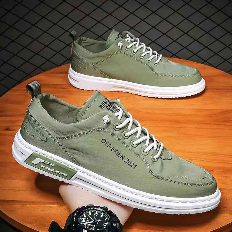 Scarpe da ginnastica verdi da uomo su tavolo in legno, design moderno con suola bianca, lacci bianchi, scritta "OFFEKIEN 2021", sfondo a rete.