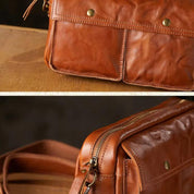 Borsa a tracolla in pelle marrone con tasche frontali e cerniera superiore, design elegante e funzionale, accessorio moda uomo e donna.