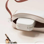 Borsa bianca in pelle aperta con pochette interna, accessori trucco e perle. Elegante e versatile, ideale per moda femminile e accessori di lusso.