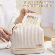 Borsa cosmetica beige con pennelli trucco, design trapuntato, chiusura a zip, ideale per organizzare accessori beauty. Perfetta per viaggi e uso quotidiano.