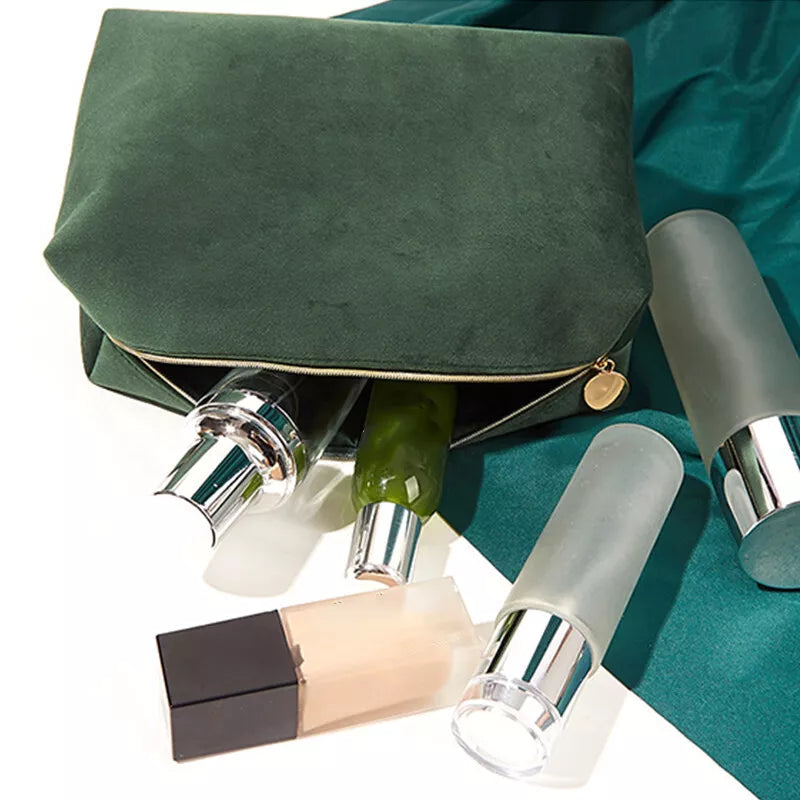 Borsa cosmetica verde con cerniera, contenente flaconi di prodotti skincare. Elegante e pratica per organizzare cosmetici e accessori di bellezza.