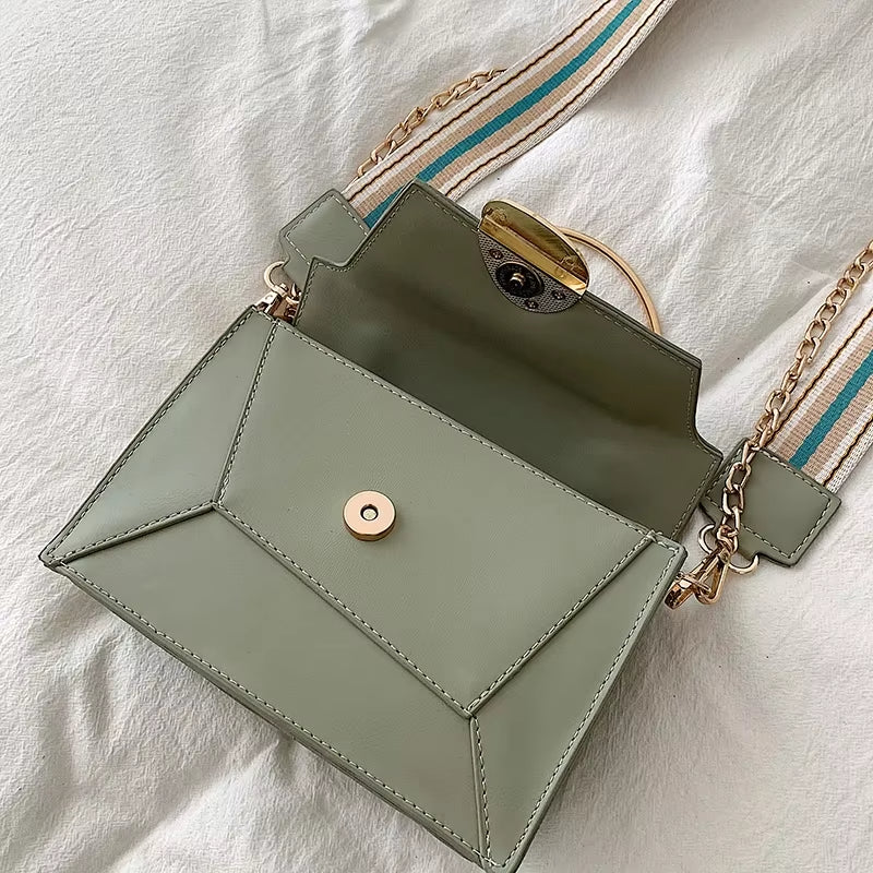 Borsa a tracolla verde salvia in pelle, design geometrico, catena dorata, chiusura a bottone, stile elegante e moderno, perfetta per ogni occasione.
