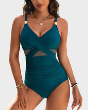 Costume intero donna verde petrolio, design incrociato, dettagli in rete, spalline regolabili, accessori dorati, moda mare elegante.