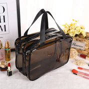 Borsa trasparente in PVC nero con manici neri, ideale per cosmetici. Design elegante, perfetta per viaggi e organizzazione trucco.