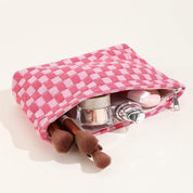 Astuccio trucco rosa a quadretti con pennelli, smalto e cosmetici. Accessorio moda donna, organizer viaggio, beauty case elegante.